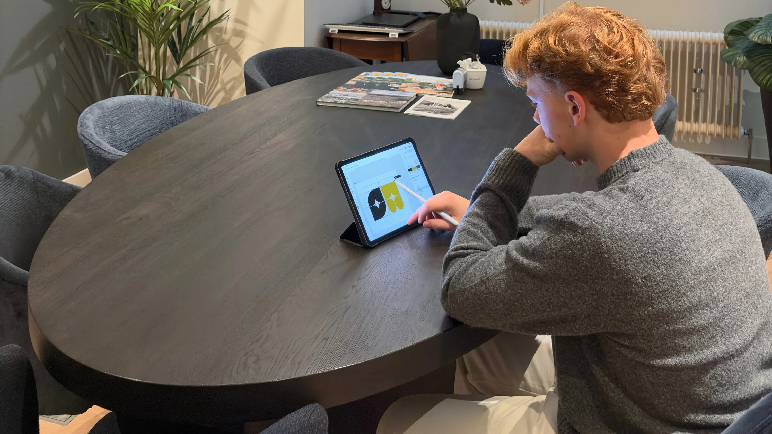 Maarten werkt aan de vergadertafel met een pencil op een iPad aan het merkteken van Studio Werf