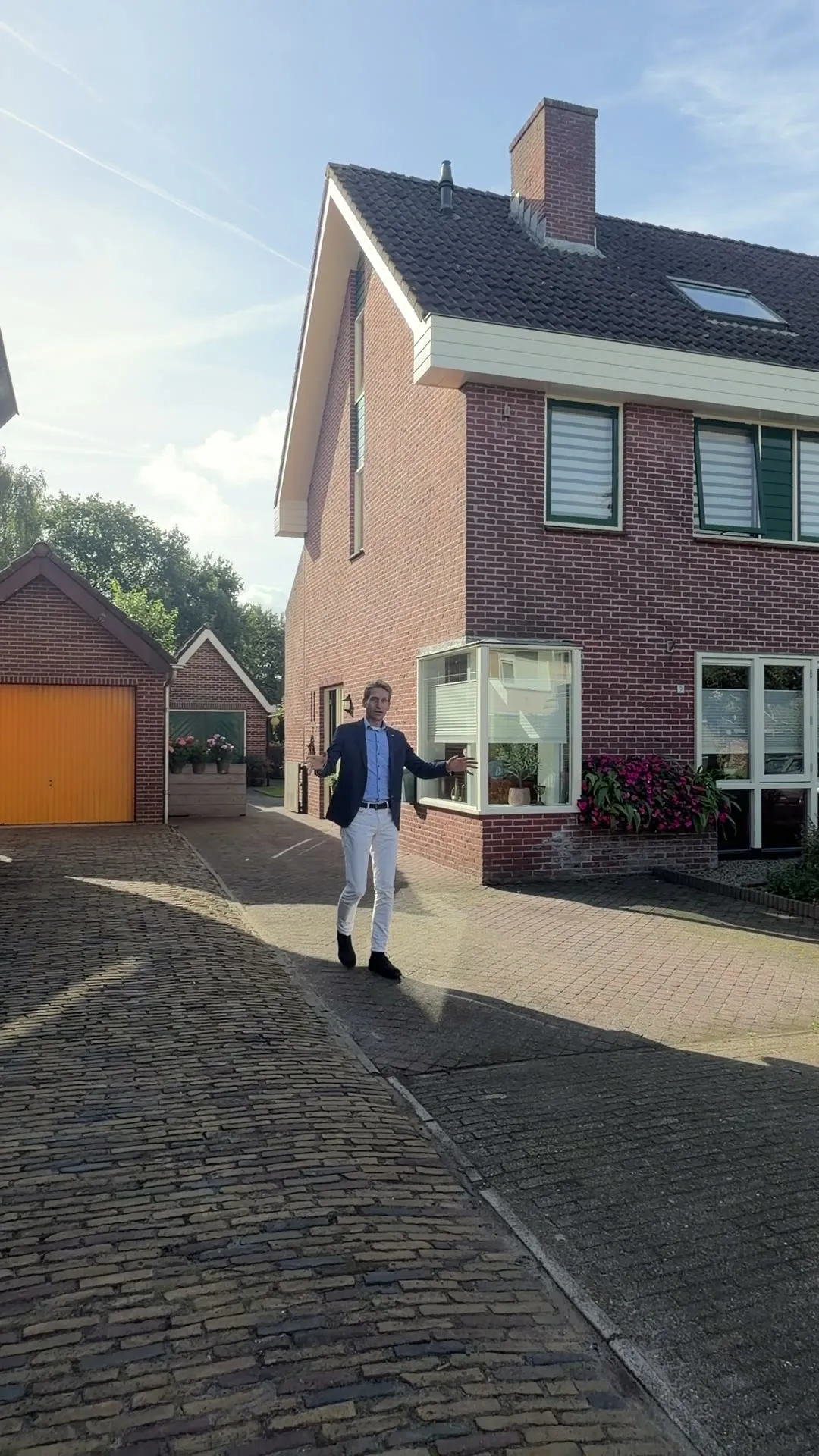 Makelaar Hans loopt over straat naar een woning in Oosterwolde